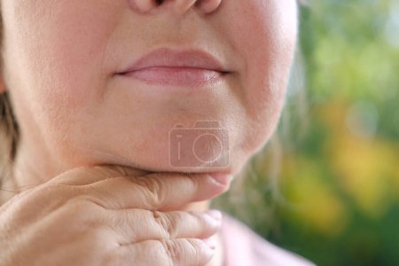 Doppelkinn Gesicht reife Frau 50 Jahre alt, menschliches Fett Hals, schlaffe Wangen, Falten auf der Haut, Facelift, altersbedingte Hautveränderungen, ästhetische Injektionskosmetologie, Pflege Anti-Aging-Verfahren