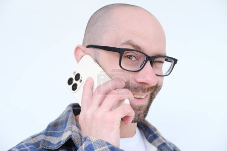 Photo for Positive charming young man in glasses using modern phone with smile, highlighting role of gadgets in everyday business communication, Digital Lifestyle - Royalty Free Image