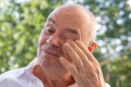 bastante hombre 60-65 años de edad con los ojos cerrados, síndrome de fatiga ocular Asthenopia, síntomas de dolor ocular, incluyendo tensión, alergias, infecciones y lesiones, agudo, sordo, palpitante o sensación de ardor