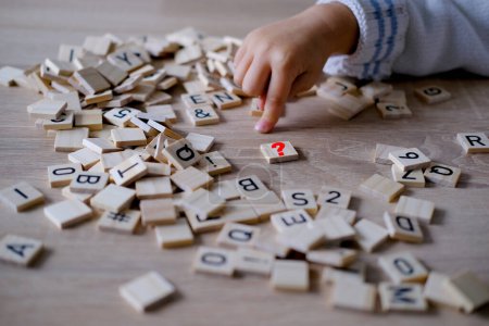 manos de cerca, niño pequeño de 3 años juega bloques de alfabeto de madera, compone palabras de letras, conciencia de dislexia, dificultades de aprendizaje, desarrollo del cerebro humano, infancia feliz, enfoque selectivo