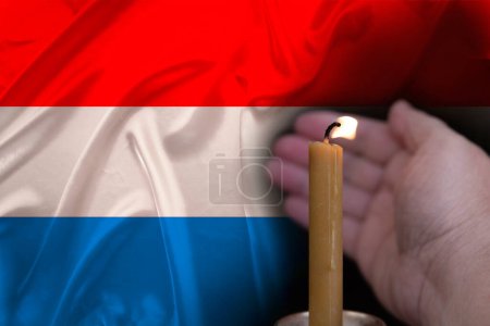 mourning candle burning front of flag Luxembourg, memory of heroes served country, grief over loss, national unity in challenging times, state's history