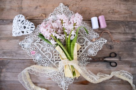 Spring bouquet of white and purple hyacinths, napkin, scissors, lace on old wooden table, Spring interior decor, Holiday greetings, new beginnings