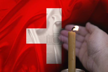 mourning candle burning front of flag Switzerland, memory of heroes served country, grief over loss, national unity in challenging times, state's history