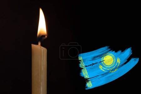 mourning candle burning front of Kazakhstan flag, Victims of cataclysm or war concept, memory of heroes served country, grief over loss, national unity in challenging times, state's history