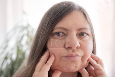 Doppelkinn-Gesicht reife Frau 50 Jahre alt, menschlicher Fetthals, Seitenansicht, Falten auf der Haut, Facelift, altersbedingte Hautveränderungen, ästhetische Injektionskosmetologie, Pflege Anti-Aging-Verfahren