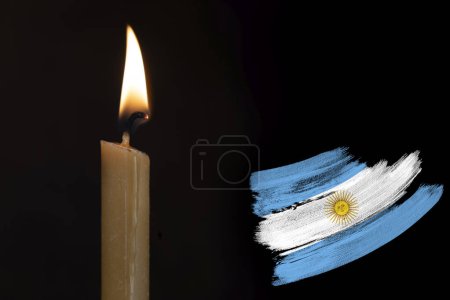 mourning candle burning front of flag Argentina, memory of heroes served country, grief over loss, national unity in challenging times, state's history