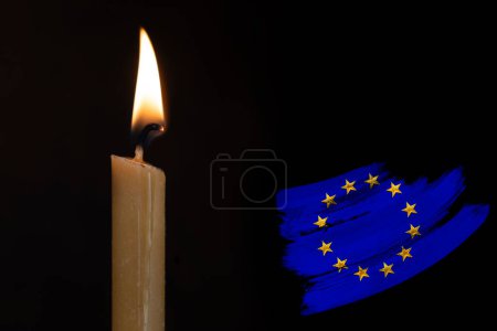mourning candle burning front of flag European Union, Victims of cataclysm or war concept, memory of heroes served country, grief over loss, national unity in challenging times, state's history