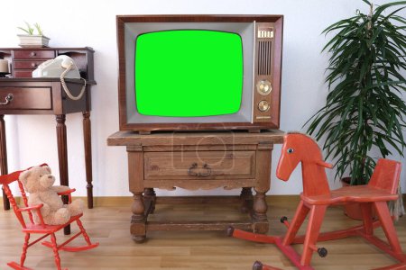 Filmmaterial Datiertes Fernsehgerät mit weißem Screen-Mock Up-Chroma-Schlüsselschablone-Display, Wohnzimmer, leeres altes Schaukelpferd, Kinderspielzeug, Retro-Stil Fernsehen, Vintage-Familienabend-TV-Konzept