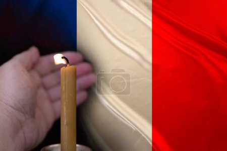 mourning candle burning front of flag France, Victims of cataclysm or war concept, memory of heroes served country, grief over loss, national unity in challenging times, state's history