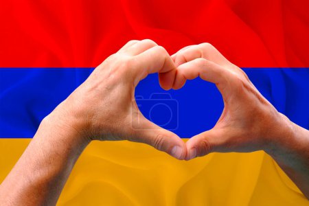 Téléchargez les photos : Gros plan des mains masculines en forme de cœur sur fond de soie drapeau national de l'Arménie, patriotes du concept de pays, fête de l'indépendance, voyage, coopération internationale - en image libre de droit
