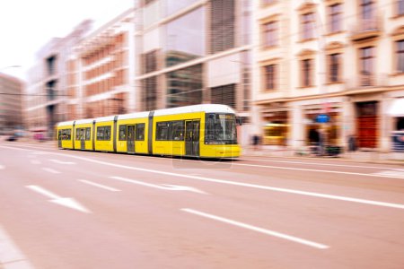 yellow tram driving down city street in Berlin, travel, tourism and city breaks, eco-friendly public transportation, sustainability and environment, Berlin, Germany