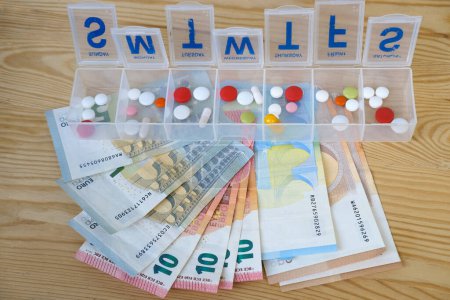 Tabletten, Kapseln, Vitamine im Pillbox Organizer für Woche, Euro-Banknoten verschiedene Stückelungen, Konzept zur Kontrolle der regelmäßigen Medikamenteneinnahme, Organisation der Medikamenteneinnahme durch den Patienten, teure Medikamente