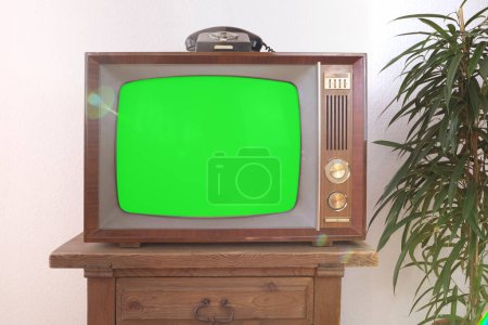 Foto de Pantalla verde, viejo retro analógico TV 1960-1970, teléfono de marcación rotatoria, pantalla en blanco para el diseñador, fondo, maqueta elegante, plantilla para video - Imagen libre de derechos