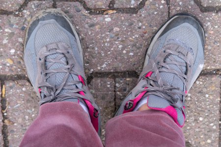 vieilles chaussures usagées, bottes de randonnée sur pied féminin sur le sol, marques d'usure, ajoutant au caractère, Pauvreté et sans-abri, Beaucoup de miles marchaient sur des baskets usées 