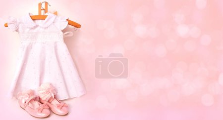 Foto de Hermosos zapatos brillantes rosados de lujo con lazos para niña, calcetines de encaje a juego, vestido blanco, equipo para la celebración, infancia feliz, preparación para las vacaciones - Imagen libre de derechos