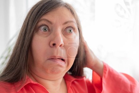 Photo for Mature very surprised frightened woman with bulging eyes, face close-up, staring in waking nightmare, Very strong surprise or shock, fright, universal horror in look - Royalty Free Image