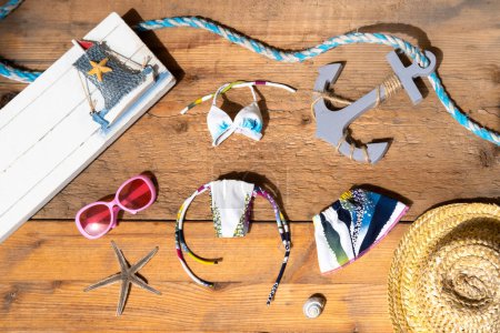summer straw hat, sunglasses, sea anchor, starfish on old wooden table, traveling with children to sea, Childhood activity for enjoyment and recreation, being relaxed and free from stress