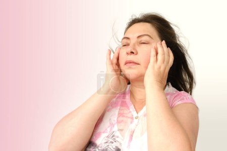 diseased mature woman experiences severe headache, holding head, Hot flashes during menopause, Decreased memory and concentration, feeling nervous, Feeling tired, exhausted, menopause, midlife crisis