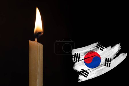 Trauerkerzen brennen vor der Flagge Südkoreas, Opfer von Kataklysmen oder Kriegskonzept, Erinnerung an Helden, die dem Land gedient haben, Trauer über den Verlust, nationale Einheit in schwierigen Zeiten, Geschichte des Staates