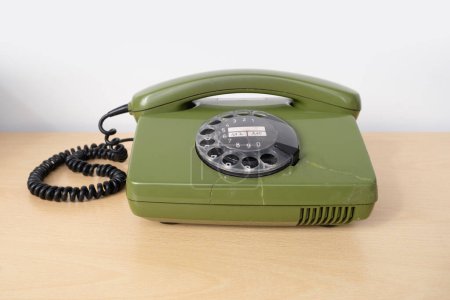 Téléchargez les photos : Ancien téléphone rotatif vert avec cadran à disque, Ancien téléphone avec fissures, Connexion avec le passé, Technologie obsolète, Communication des années 80 - en image libre de droit