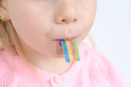 Kind, Mädchen 4 Jahre alt genießt gallertartige Süßigkeiten, bunte Regenbogenzuckermarmelade, glückliche Kindheit, süßes Leben, ungesundes Essen, Halal-Essen, zuckerhaltige Leckereien, Kinderernährung