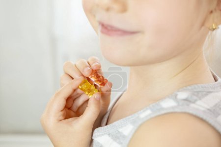 Photo for Close-up preschool child, girl 5 years old wants eat gelatinous sweets, gummy bear, kid has good appetite, happy childhood, balanced diet, sweet life, unhealthy food, halal food - Royalty Free Image