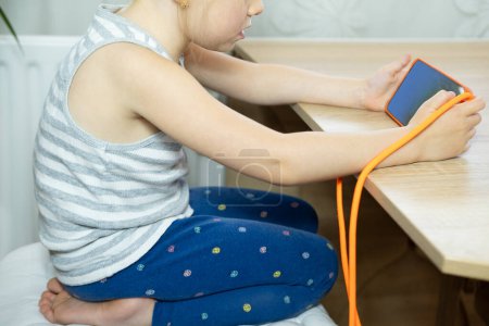 young girl Hunched over mobile device, child neglects physical posture, negative effects With neck craned and shoulders rounded