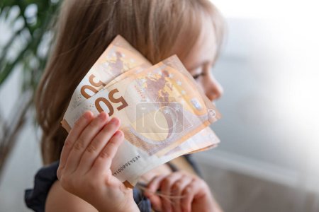 weibliches Kind, Mädchen hält 50-Euro-Scheine in Nahaufnahme, Träume und Möglichkeiten scheinbar unbegrenzt, Taschengeld, Finanzkompetenz