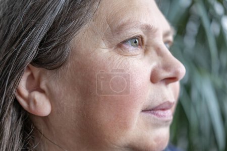 Kaukasische positive 50-jährige attraktive Frau, die in die Kamera schaut, hübsches Porträt aus nächster Nähe, Falten auf der Haut, Facelift, altersbedingte Hautveränderungen, Pflege Anti-Aging-Verfahren