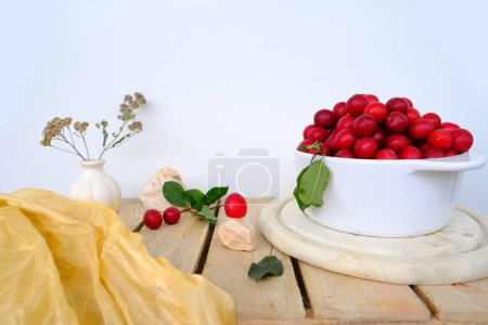 Photo for Large white bowl with wild cherry plum, fresh juice fruit and berry on wooden boards, concept of healthy eating, vegan diet, raw food, healthy food, ingredients for making tkemali sauce - Royalty Free Image