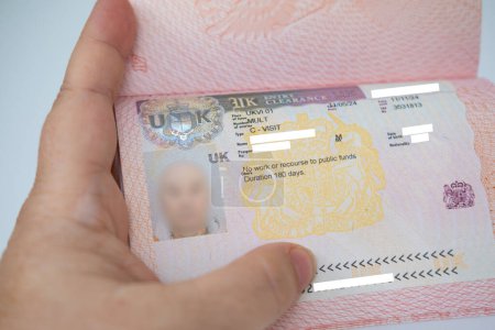 Detailed view of British United Kingdom tourist visa in passport, showing UK travel multivisa in close-up, official document, travel approval
