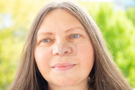 Kaukasische positive 50-jährige attraktive Frau mit langen Haaren posiert anmutig, hübsches Gesicht Nahaufnahme Porträt, Pflege Anti-Aging-Verfahren
