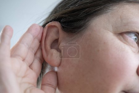 caucasian mature woman difficulty hearing, cerumen impaction, hearing loss, medical concept, loud sounds, middle ear inflammation, ototoxic medicines