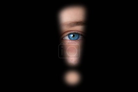 close-up of part of face, serious eye looking through hole exclamation point in dark, concept of seeing scary, stress problems, domestic violence, difficult childhood, problems of growing up children