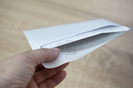 close-up shot of female hand holding white paper envelope, receiving Mail, letter, message concept, important news or personal communication, election day