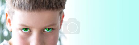 Nahaufnahme bionischer Augen, kaukasisches Kind, aggressiver Junge, der seitwärts schaut, intensives Starren, entschlossen, sich durchzusetzen