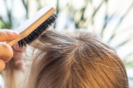 wooden comb, brush in female hand, woman, loving mother brushes, combing daughter's hair, young girl, daily care and affection
