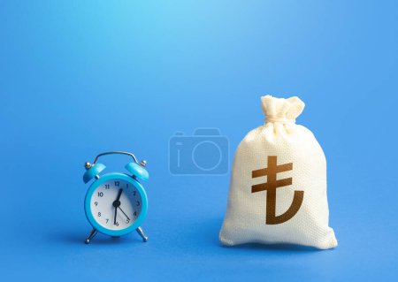 Photo for Blue clock and turkish lira money bag. Loans, mortgages. Retirement funds. ROI. Bonds, dividends. Bank, finance. Investments. Hourly pay. Time of payment in the contract. Taxation. Deposits, savings. - Royalty Free Image