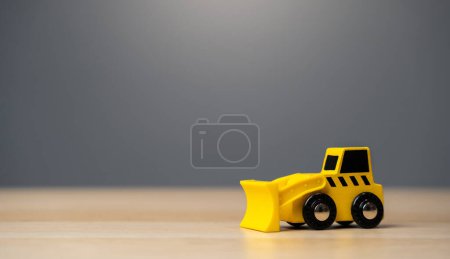 Téléchargez les photos : Le jouet bulldozer jaune. Travaux de construction. Déblayer et niveler la terre. Destruction des bâtiments. Abattez la construction illégale. Industrie - en image libre de droit
