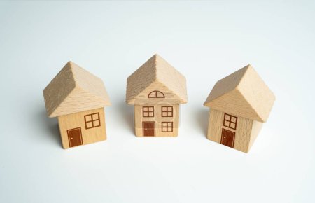 Drei Spielzeughäuser aus Holz. Kauf und Verkauf von Wohnungen. Sachversicherung. Immobilienmarkt-Review. Ausländische Immobilien und Vorteile aus dem Kauf in anderen Ländern und Gerichtsbarkeiten