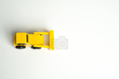 Photo for Yellow toy bulldozer, top view copy space. Metaphor to remove something, demolish. Construction works. Clearing and leveling the land. Building destruction. Take down Illegal construction. Industry - Royalty Free Image