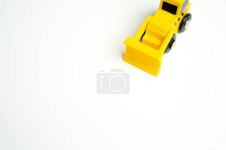 Téléchargez les photos : Jouet bulldozer jaune et placer pour le texte sur un fond blanc. Services de démolition, nivellement et autres travaux de terrassement. Détruisez les bâtiments illégaux. Industrie machines à louer - en image libre de droit