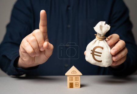 Asesor financiero advierte sobre la compra de bienes raíces. Hombre con signo de atención dedo sosteniendo euro bolsa de dinero. Elegir los mejores términos de préstamo hipotecario para la compra de bienes raíces. Convertirse en propietario de una casa.