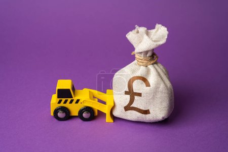 Photo for A bulldozer pushes a british pound sterling money bag. Ineffective use of funds. Money down the drain. Financing of dismantling works. Demolition. Industry machinery for rent. Wasted resources. - Royalty Free Image
