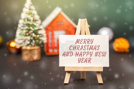 Easel with the words Happy New Year and Merry Christmas. New Year or Xmas winter holiday. Decoration, celebration. The concept of the beginning of the new year. Snow, snowfall