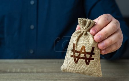 Photo for A man holds out a south korean won money bag. Economics and currency exchange, stock market. Deposits and savings. Banks and finance. Investments, fundraising. Funding and grants. Loans, mortgage. - Royalty Free Image