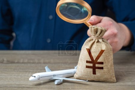 Airplane and chinese yuan or japanese yen money bag under investigation. Economic impact of aviation industry. Payment of taxes, fees and excise taxes. Measure impact on local economy.
