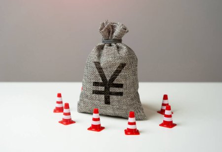 Money bag with chinese yuan or japanese yen symbol blocked by road cones. National money reserve. Freezing of accounts and sanctions on capital. Suspicious funds with unknown sources.