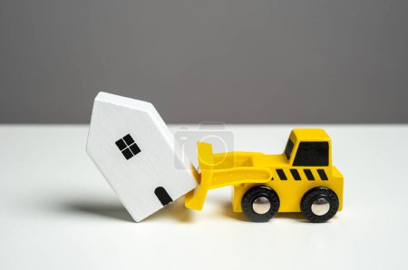 Téléchargez les photos : Démolition d'une maison avec un bulldozer. Le bulldozer veut démolir la maison. Faire place aux développements futurs. Service de compensation territoriale. - en image libre de droit