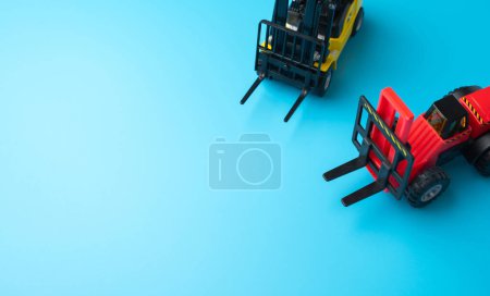 Forklifts and space for text on a blue background. Efficient logistics and distribution systems. Management of warehousing and shipping of orders and goods.